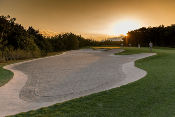 sun sets over sand dune at el camaleon golf course